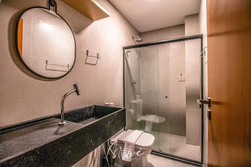 a bathroom with a shower and a sink and a mirror at Studio perfeito na Rota de Milagres in Pôrto de Pedras