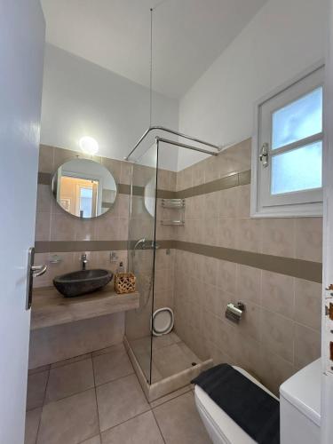a bathroom with a sink and a glass shower at Το Αίθριο in Galissas