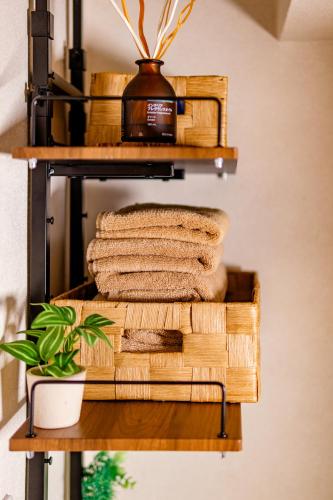a stack of wooden baskets and towels on a shelf at HARERUYA Inn SHINJUKU in Tokyo