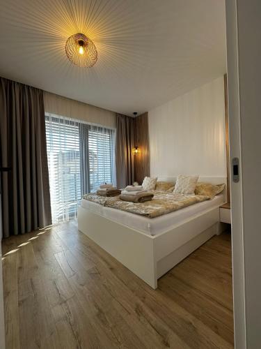 a bedroom with a large bed with a large window at Apartmán FILIP v centre Žiliny in Žilina