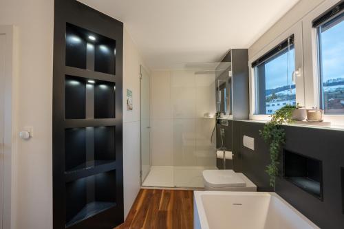 ein Badezimmer mit einer weißen Toilette und einer schwarzen Tür in der Unterkunft View Pilatus-Luxus-Maisonette mit Pilatusblick - 6 Personen - PP in Luzern