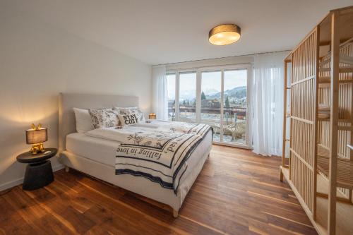 ein Schlafzimmer mit einem Bett und einem großen Fenster in der Unterkunft View Pilatus-Luxus-Maisonette mit Pilatusblick - 6 Personen - PP in Luzern