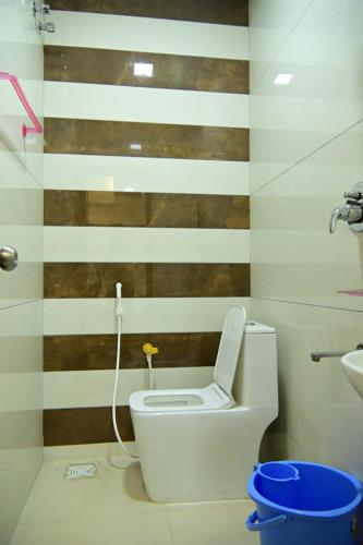 a bathroom with a toilet and a sink at VRJInn in Vellore