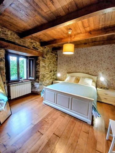 a bedroom with a bed in a room with wooden floors at Lar das louseiras in Rozabragada