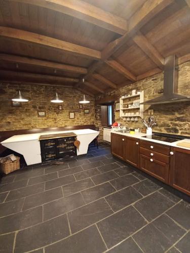 a large kitchen with a sink and a stove at Lar das louseiras in Rozabragada