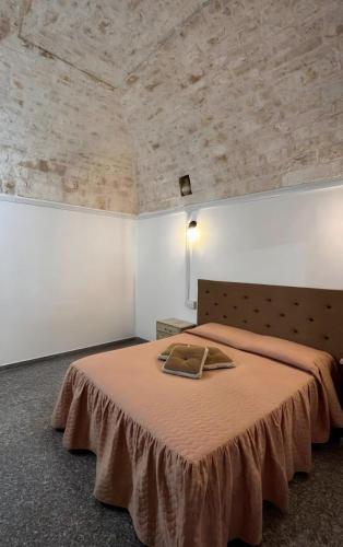 a bedroom with a large bed with a brown blanket at Casa Renza in Locorotondo