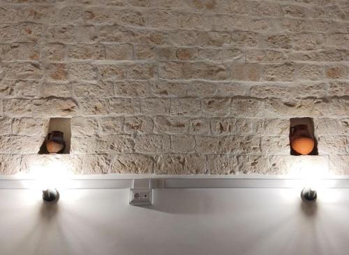 two lights in front of a stone wall at Casa Renza in Locorotondo