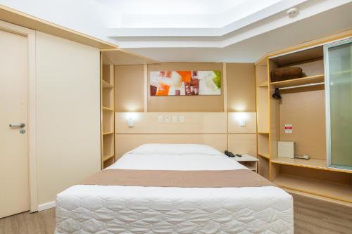 a bedroom with a large white bed in a room at Hotel Metropolitan Canoas in Canoas
