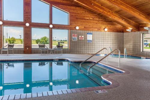 a swimming pool in a building with tables and chairs at MountainView Lodge and Suites in Bozeman