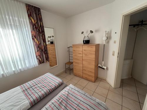 a bedroom with a bed and a dresser and a window at Ferienwohnung Andresen in Rerik