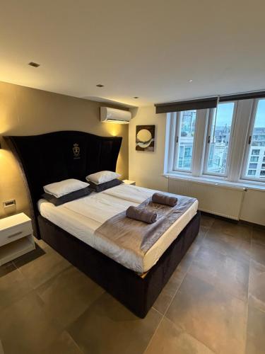a bedroom with a large bed in a room with windows at Loft City View in Budapest