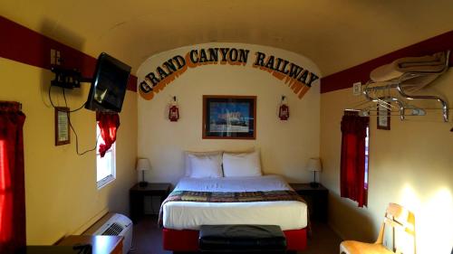 a hotel room with a bed and a tv at Historic Rail car on route 66 in Williams