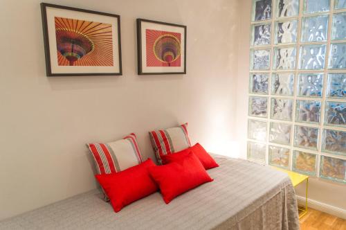 Un dormitorio con una cama con almohadas rojas.  en For You Rentals Centro de Madrid apartment LM7, en Madrid