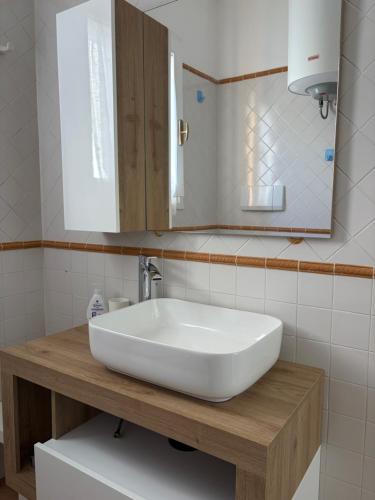 a bathroom with a white sink and a mirror at Residence Le Solane in Marina di Campo