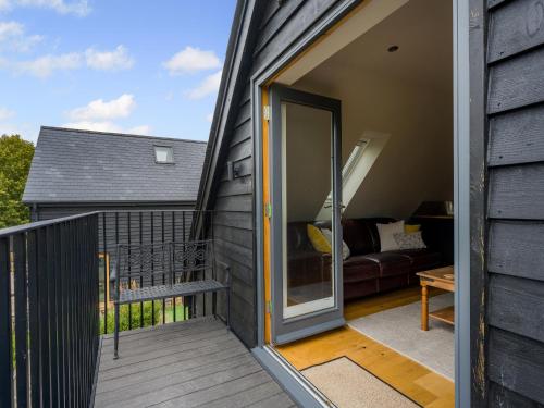 a sliding glass door on a deck with a couch at Pond View Loft in Sudbury