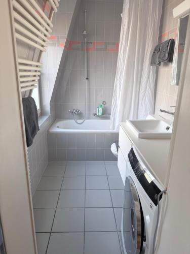 a white bathroom with a tub and a sink at Apartments Justingerweg Bern in Bern