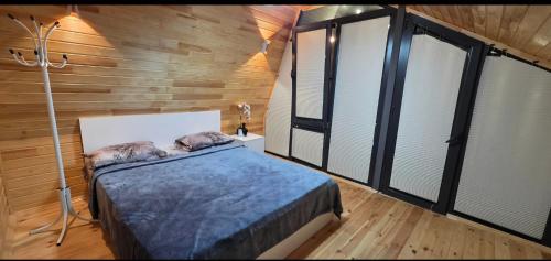 a bedroom with a bed in a room with windows at Rest House İsmayıllı A frame in İsmayıllı