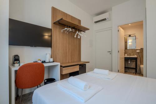 a bedroom with a white bed and a desk and a chair at Italianflat - Vandom 2 Duomo Luxury Rooms Foresteria Lombarda in Milan