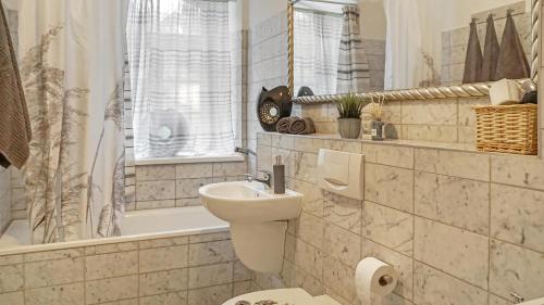 a bathroom with a sink and a toilet and a tub at Apartment am Nationalpark Sächsische Schweiz in Sebnitz