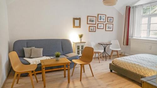 a living room with a couch and chairs and a bed at Apartment am Nationalpark Sächsische Schweiz in Sebnitz