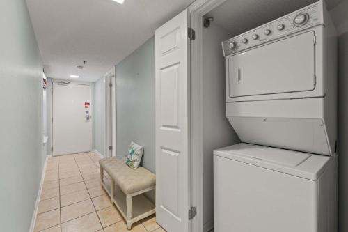 a white laundry room with a washer and dryer at Barefoot Getaway in Orange Beach