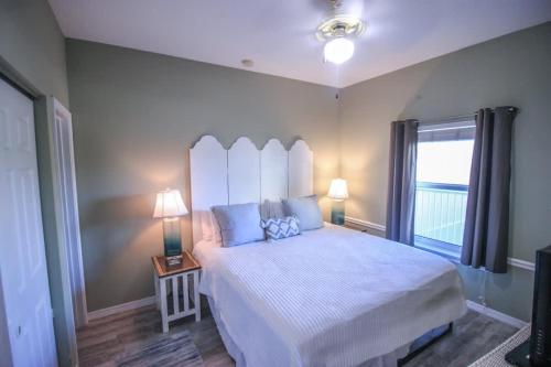 a bedroom with a large bed and a window at Sunsets and Palms in Gulf Shores