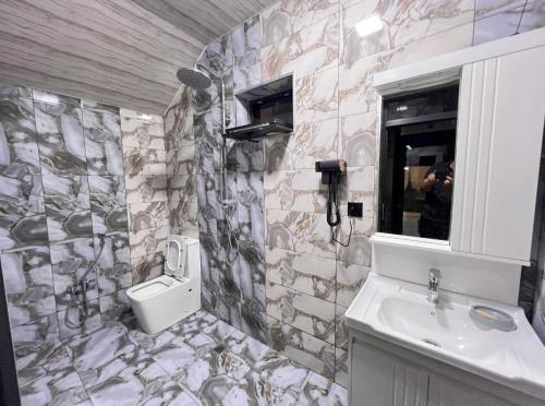 a stone bathroom with a sink and a toilet at Rest House İsmayıllı A frame in İsmayıllı