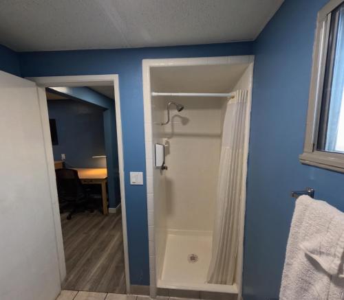 a bathroom with a shower and a blue wall at Heritage Inn - Milpitas in Milpitas