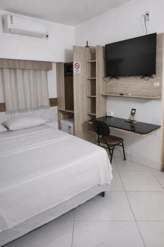 a bedroom with a bed and a flat screen tv at Hotel orla House in Petrolina