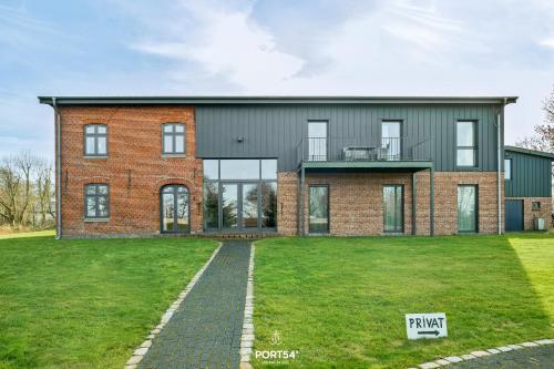a brick house with a green lawn in front of it at Ferienwohnung Lille Hus 3 St Peter-Ording in Böhl