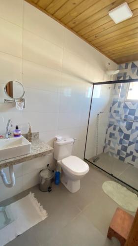 a bathroom with a toilet and a sink and a shower at Chalé beira mar in Prado