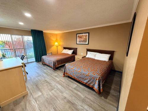 a hotel room with two beds and a window at Heritage Inn - Milpitas in Milpitas