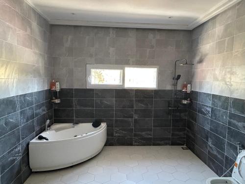 a bathroom with a bath tub and a window at Ocean Gem in Bakau