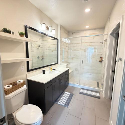 a bathroom with a toilet and a sink and a shower at Luxury Downtown Houston Skyline Suite in Houston