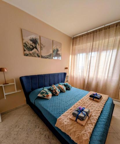 a bedroom with a blue bed with two towels on it at In Via Capri 1991 APARTMENT in Follonica