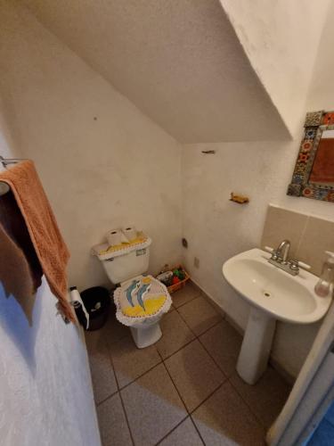 a small bathroom with a sink and a toilet at Casa de playa El Artesano in Ixtapa