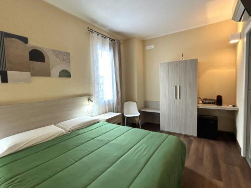 a bedroom with a green bed and a cabinet at Affittacamere In Centro in Tortolì