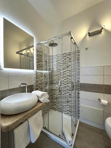 a bathroom with a glass shower and a sink at Affittacamere In Centro in Tortolì