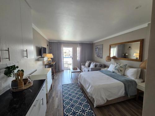 a bedroom with a bed and a living room at ShipsBell 5B in St Francis Bay