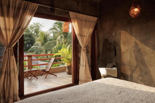 a bedroom with a bed and a large window at Hotel Boutique Pikiliki - ADULTS ONLY in Brisas de Zicatela