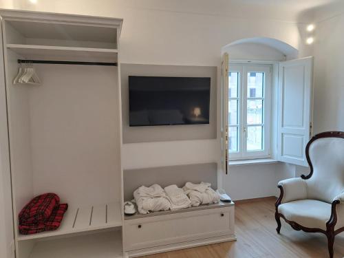a living room with a tv and a chair at Antica Dimora Petito Luxury in Matera