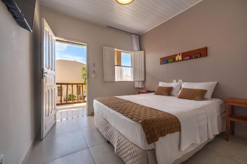 a bedroom with a large bed and a window at Pousada Jangadeiro in Porto Seguro