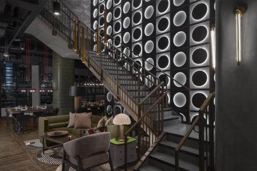 a spiral staircase in a lobby with a couch and chairs at Motto By Hilton Nashville Downtown in Nashville