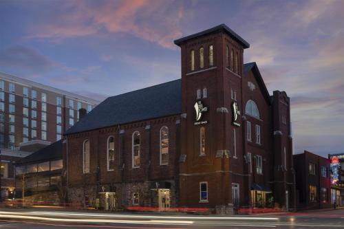 a large brick building with a clock tower on a street at Motto By Hilton Nashville Downtown in Nashville