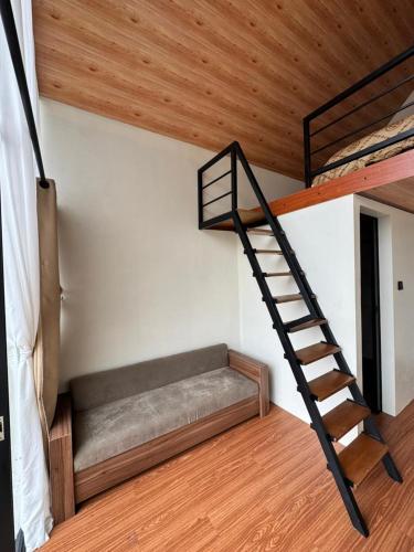a room with a bunk bed and a staircase at KALUNA cabin in Kejajar