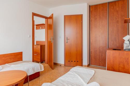 a bedroom with two beds and a table and a mirror at Natural Mielno in Mielno