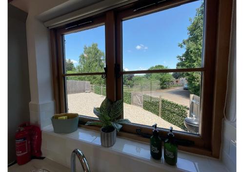a kitchen window with a view of a street at The Saddlery Barn Retreat in Ashford