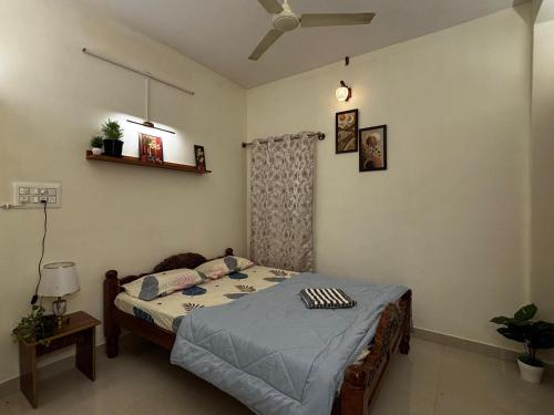 a bedroom with a bed with a blue comforter at Hazel's ELiTE Homestay 2bhk in Mysore