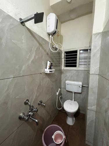 a bathroom with a toilet and a hair dryer on the wall at Hazel's ELiTE Homestay 2bhk in Mysore