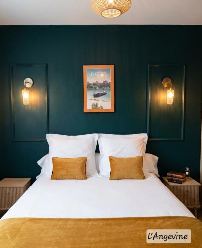 a bedroom with a large white bed with green walls at Chambres d'hôtes "Chez Lyly et Juju" Piscine&Sauna Parking Gratuit in Angers